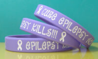 3 purple epilepsy awareness wristbands stacked on top of eachother